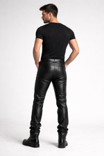 Man wearing black leather pants and boots on a white background