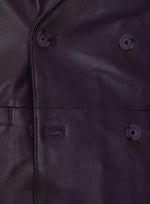 Close-up of a dark purple coat with buttons and a brand logo.