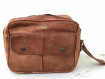 Brown leather bag with a strap on a white background