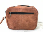 Brown leather bag with a black zipper on a white background