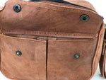 Close-up of a brown leather bag with metal rivets on a white background