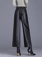 Black leather pants worn by a person on a gray background