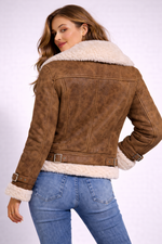 Woman wearing a brown leather jacket with white fur lining on a white background