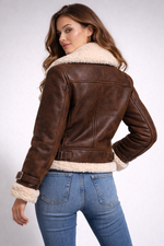 Woman wearing a brown leather jacket with white fur lining on a white background