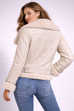 Woman wearing a beige leather jacket with fur trim on a white background