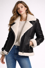 Woman wearing a black leather jacket with white fur trim on a white background