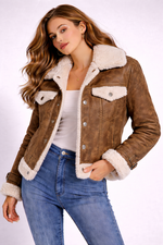 Woman wearing a brown shearling jacket with white fur trim on a white background