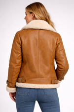 Brown leather jacket with white fur lining worn by a person on a white background